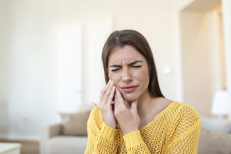 Tooth Pain And Dentistry. Beautiful Young Woman Suffering From Terrible Strong Teeth Pain, Touching Cheek With Hand. Female Feeling Painful Toothache. Dental Care And Health Concept. High Resolution